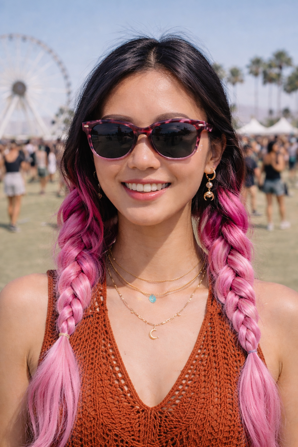 Woman with pink braided hair wearing pink frame sunglasses at a festival.