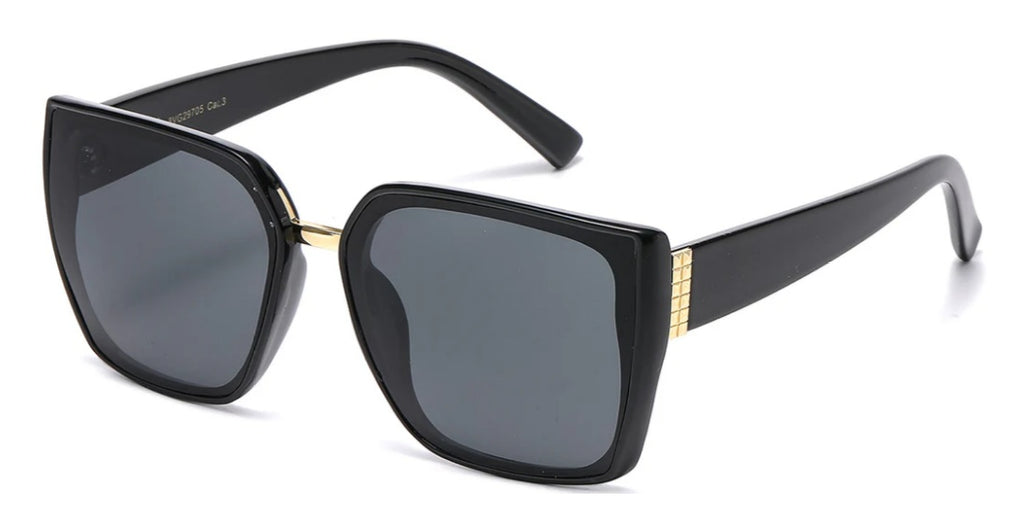 Oversize lens black sunglasses with dark lenses and gold accent at the temples on a white background