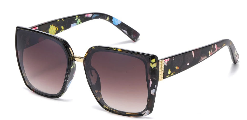 Oversize lens sunglasses in brown with floral patterned arms on a white background